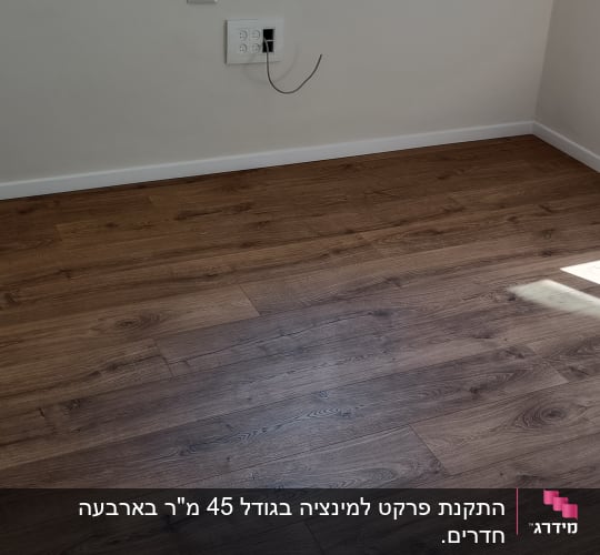 רצפת פרקט עץ כהה בחדר ריק עם אור שמש
